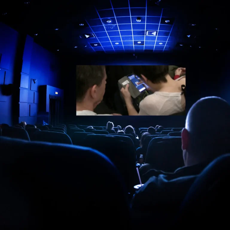 Cinema or theater in the auditorium. people watching a movie. Mockup with white blank screen.